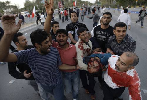 Opositores trasladan a un herido al hospital, tras el ataque perpetrado este viernes por el ejército de Bahrein. Foto: AP