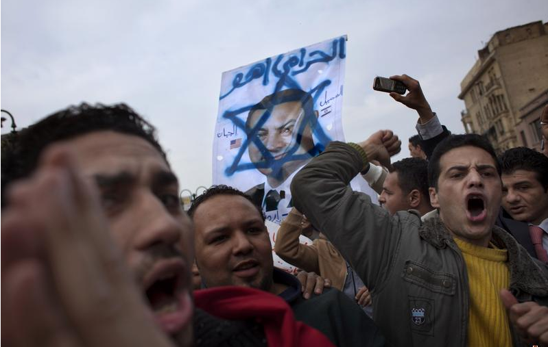 Manifestantes egipcios con un retrato de Mubarak dentro de la estrella de David, símbolo de Israel(AP Photo/Emilio Morenatti)