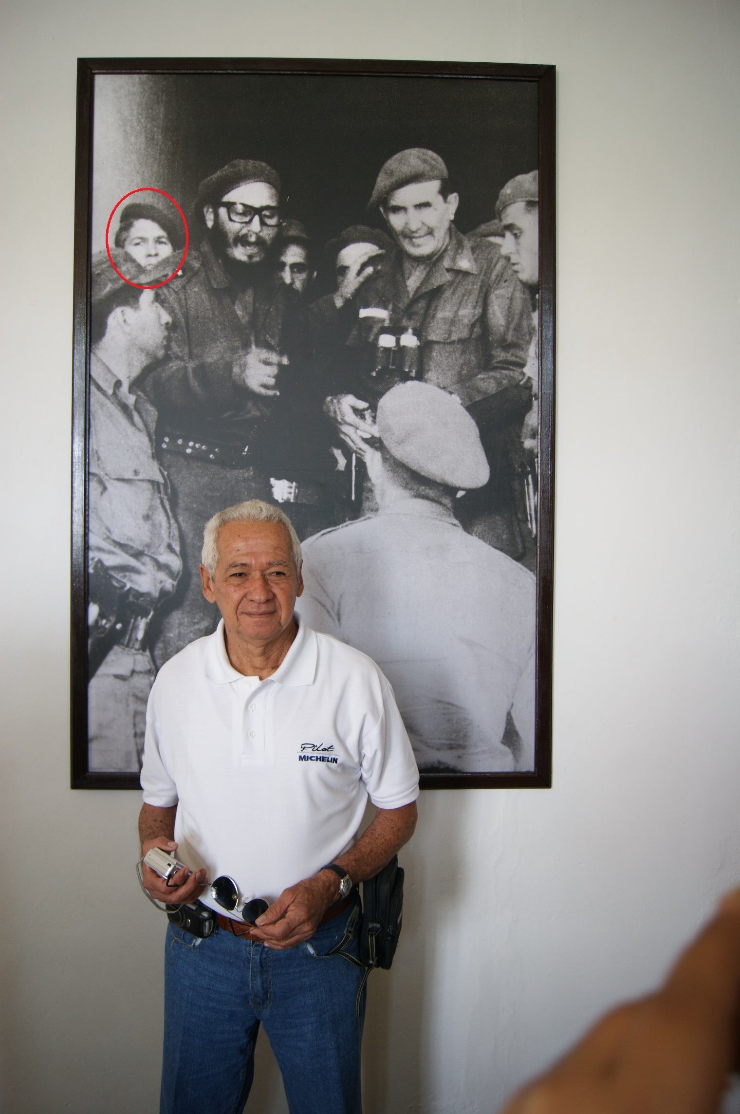 Ángel López Barrios hoy, detrás la foto en que aparece junto a Fidel en los días de Girón. 